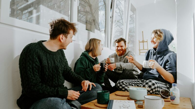 Grupo de personas sentadas alrededor de una mesa de madera