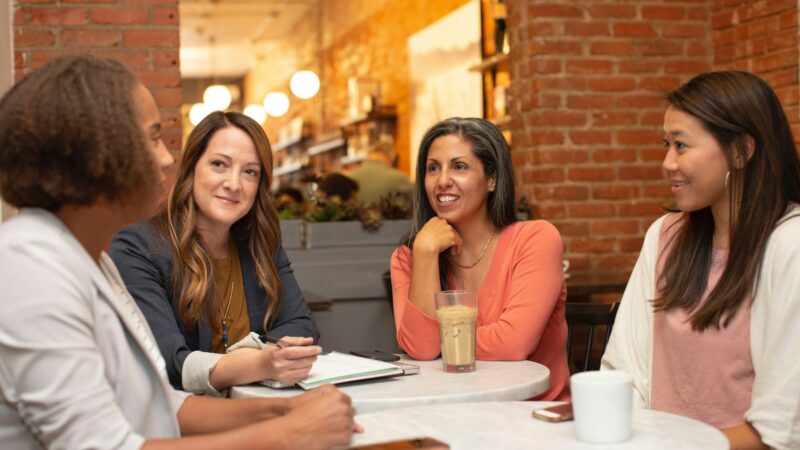 Cuatro mujeres charlando en la mesa de una cafetería