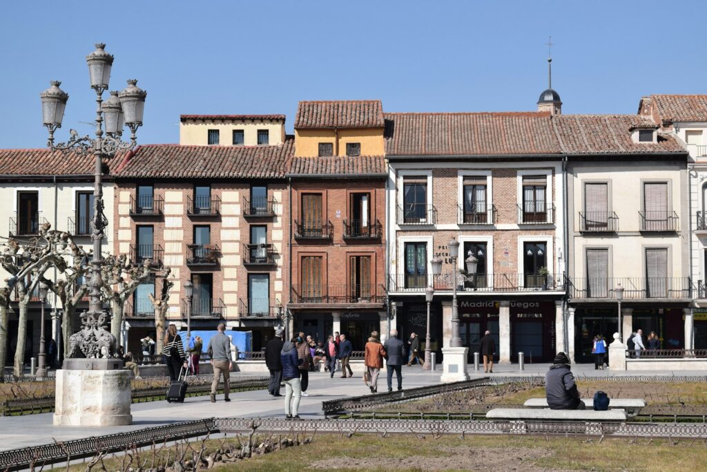 Personas paseando por una calle con edificios históricos, ruta para ver Alcalá de Henares en un día
